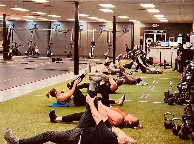 A large group strength and conditioning class on the Our House Studios floor
